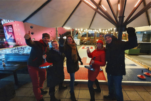 Das Team jubelt vor den Eisstockbahnen auf der Dachterrasse des Spreegold Stores im Bikini Berlin.
